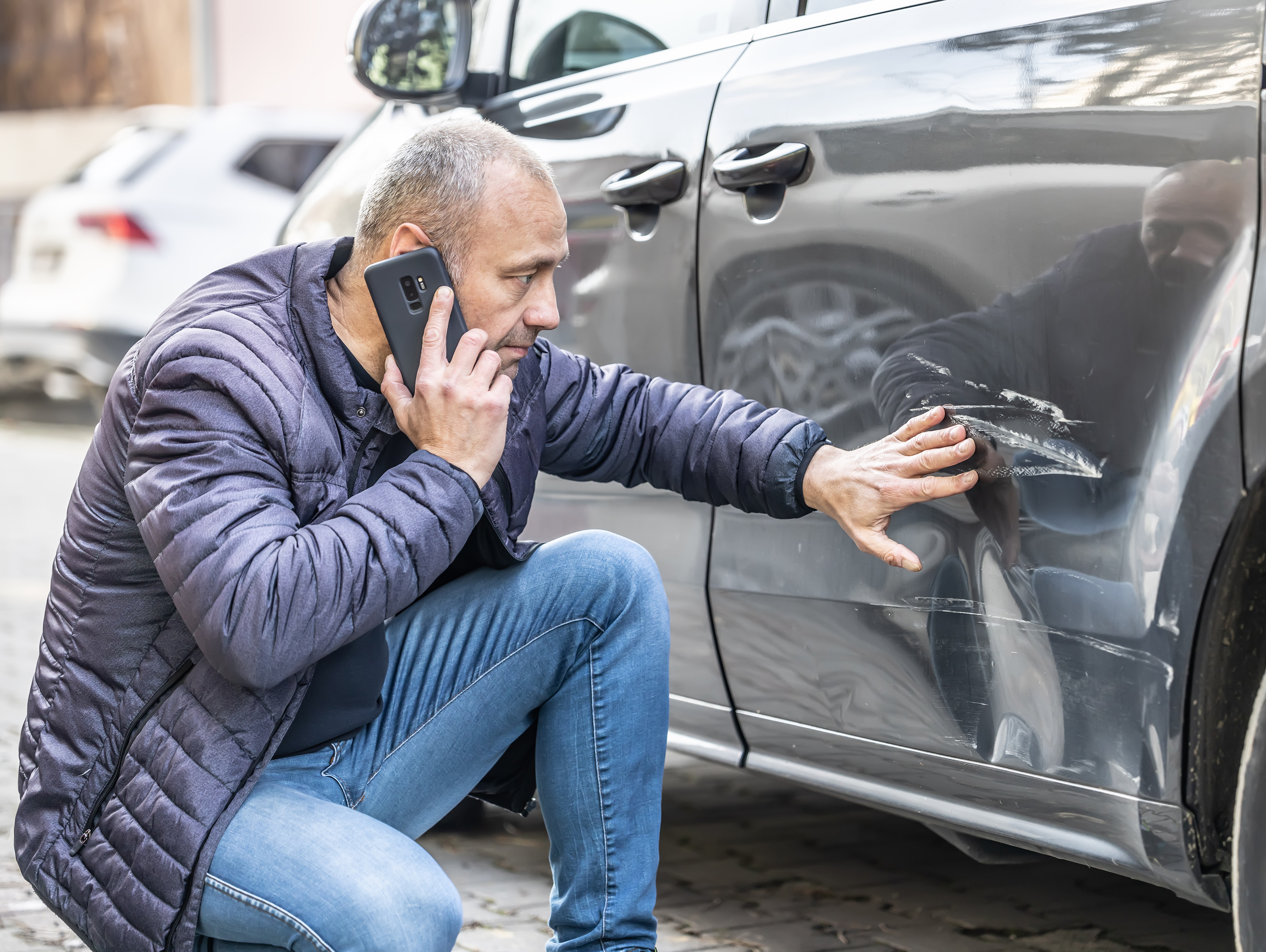 Man Looking at Damaged Car