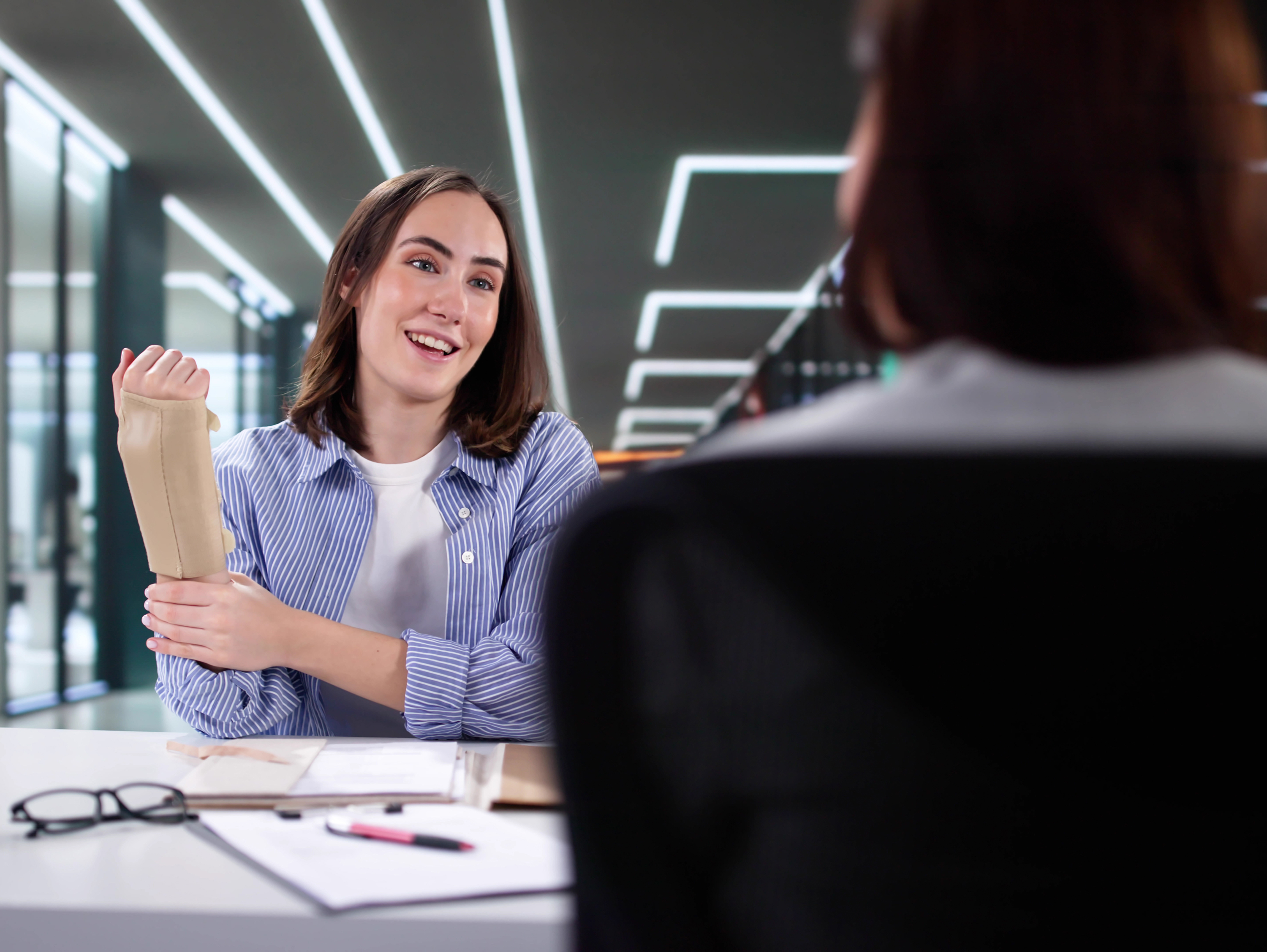 Woman with Arm Brace Talking with Woman