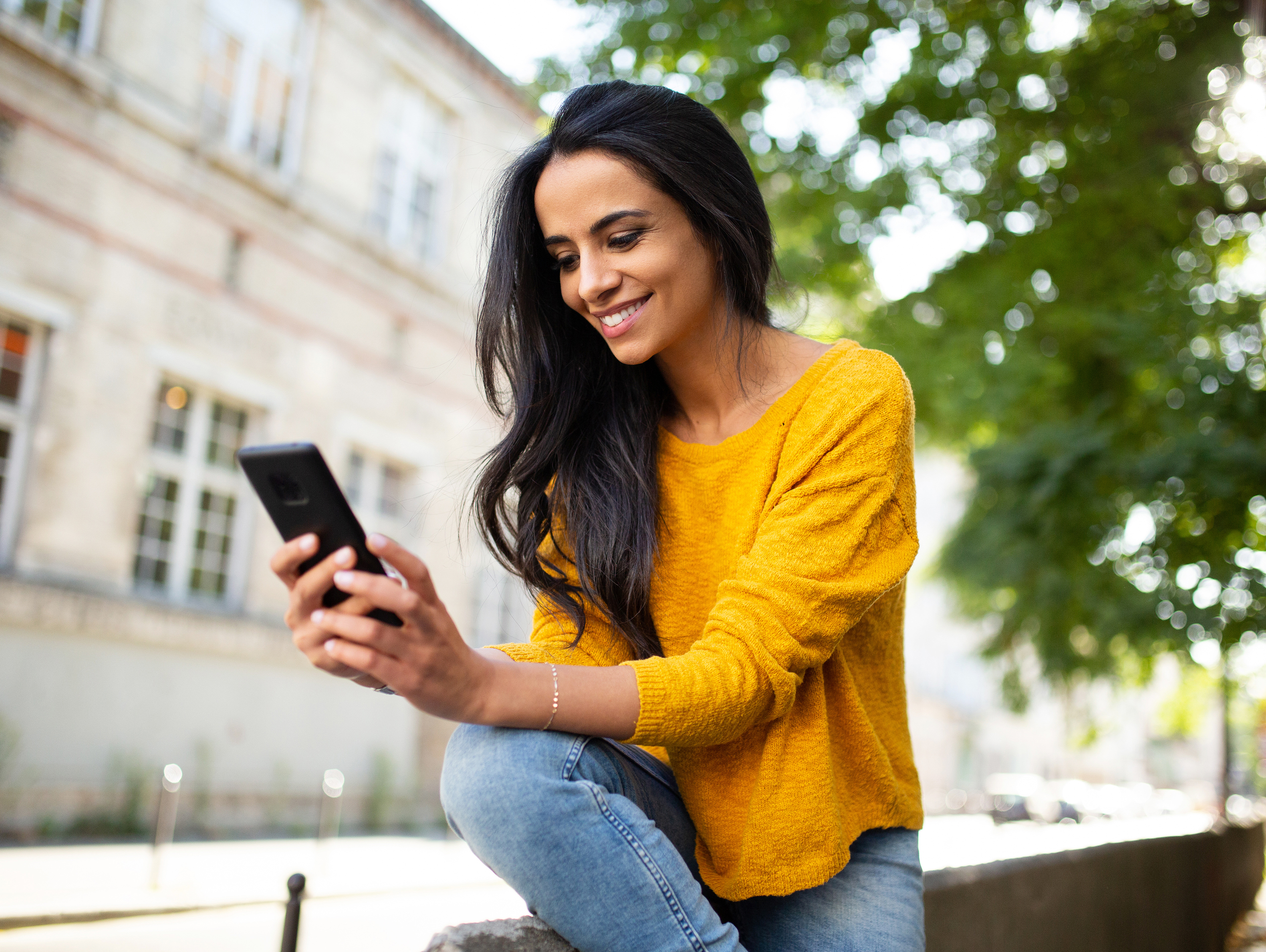 Woman Sitting Outside Looking at Phone